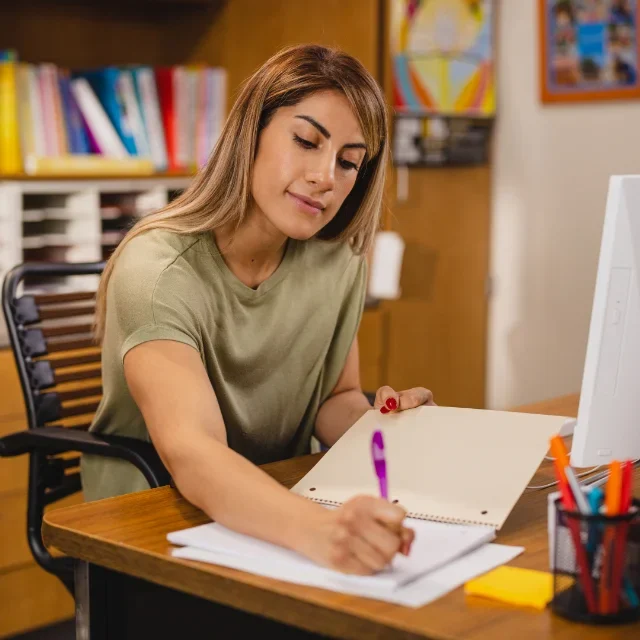 Woman taking notes at desk
